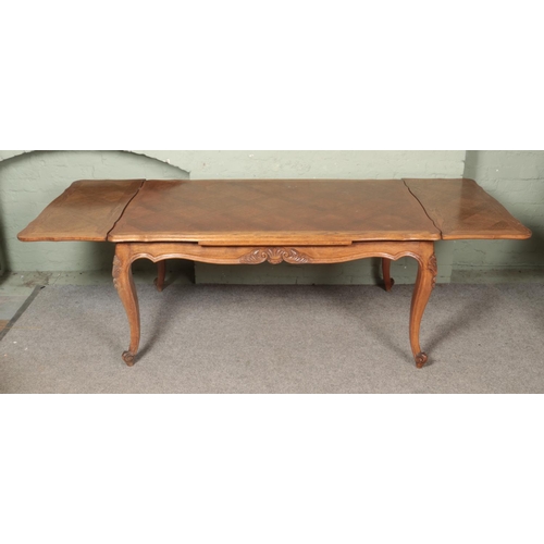 609 - A French provincial oak extending draw leaf top table with parquetry top and carved frieze on carved... 