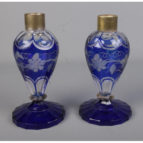 101 - A pair of blue flash glass vases featuring grape vine design with silver plated mounts.