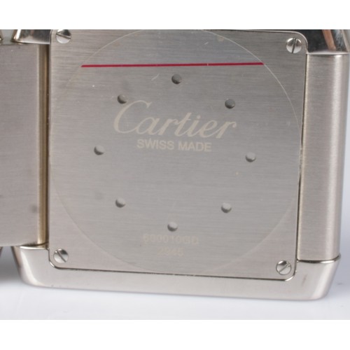 1 - A Cartier Tank Francaise stainless steel dual time folding desk/travel alarm clock. Having white and... 