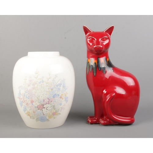 120 - Two pieces of Poole Pottery to include figure of a cat in the Red Delphis pattern (Right) and cream ... 