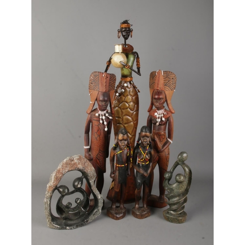 145 - A collection of metal, wood and stone tribal figures. Includes two pairs of carved wooden examples w... 