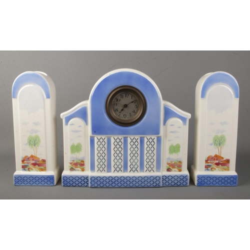 146 - An Art Deco ceramic clock garniture.