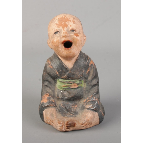 171 - A Chinese pottery incense burner modelled as a seated child. Height 10cm.