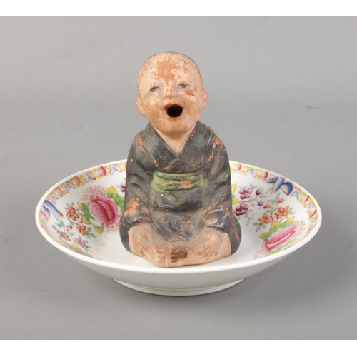 171 - A Chinese pottery incense burner modelled as a seated child. Height 10cm.