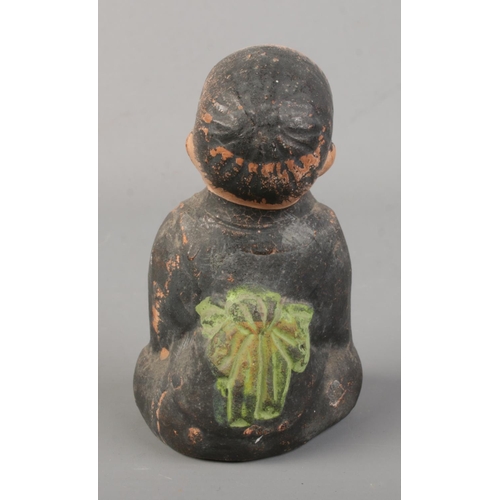 171 - A Chinese pottery incense burner modelled as a seated child. Height 10cm.