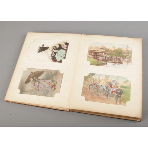 183 - A black lacquered album filled with oriental late 19th early 20th century postcards (approx 100 card... 