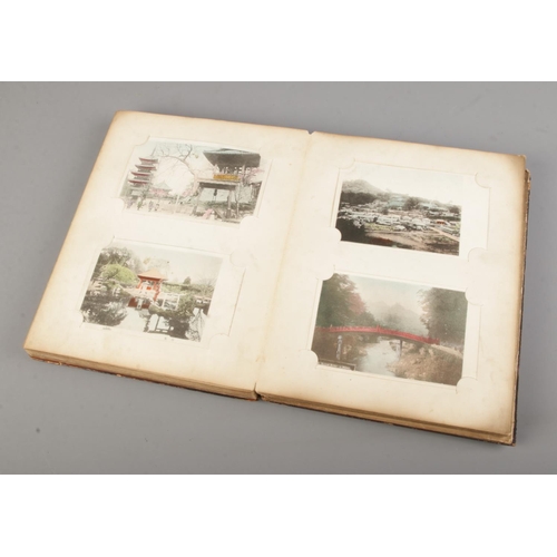 183 - A black lacquered album filled with oriental late 19th early 20th century postcards (approx 100 card... 