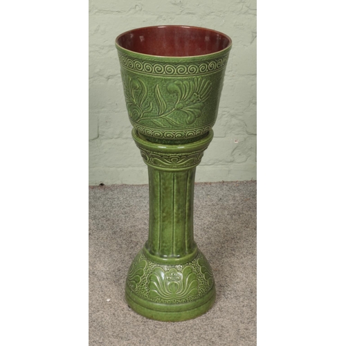 283 - A West German pottery jardiniere/plant stand depicting floral motifs.