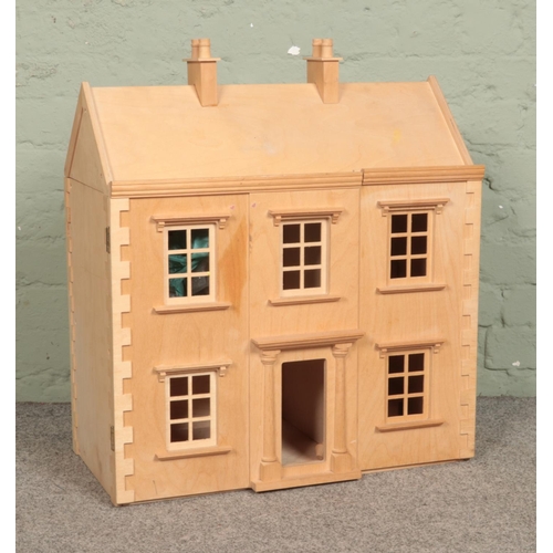 296 - A wooden three-storey dolls house, with a small quantity of furniture.