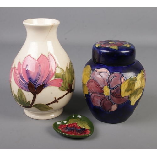 61 - Three pieces of Moorcroft pottery. Includes Hibiscus heart shaped pin dish, ginger jar and vase.