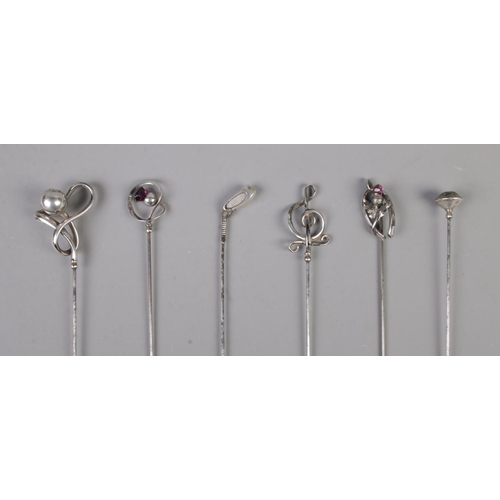 473 - A collection of six silver hat pins including golf club and amethyst examples