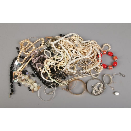 74 - A collection of jewellery including simulated pearls, a small amount of silver including bangles and... 