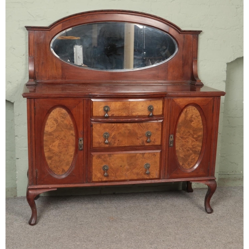 527 - A Victorian walnut mirror back sideboard, with row of three drawers flanked by cupboard doors. Raise... 