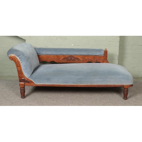 532 - A Victorian oak chaise longue, with carved detailing to the front scrolling and back plate; having p... 