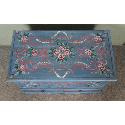 534 - A painted pine mule chest with hinged top and two lower drawers. Featuring all over floral detailing... 