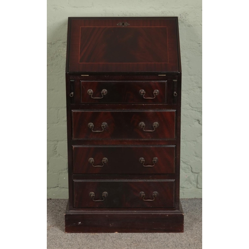 538 - A mahogany bureau of slender proportions, with drop down top revealing fitted interior, below four d... 