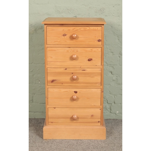 543 - A pine slender chest of five drawers.