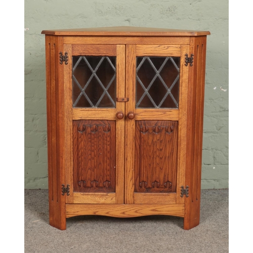 545 - A small oak linen fold corner cabinet.