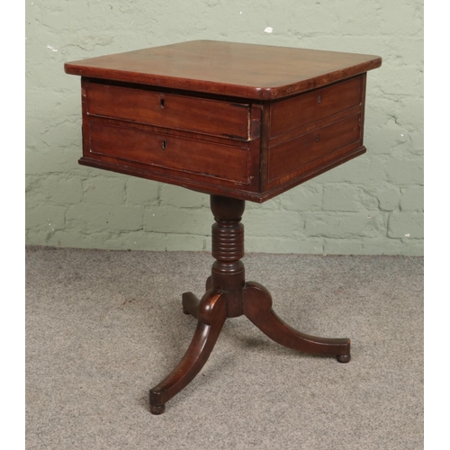 547 - A mahogany work box with two drawers and matched faux drawers to each side standing on triform pedes... 