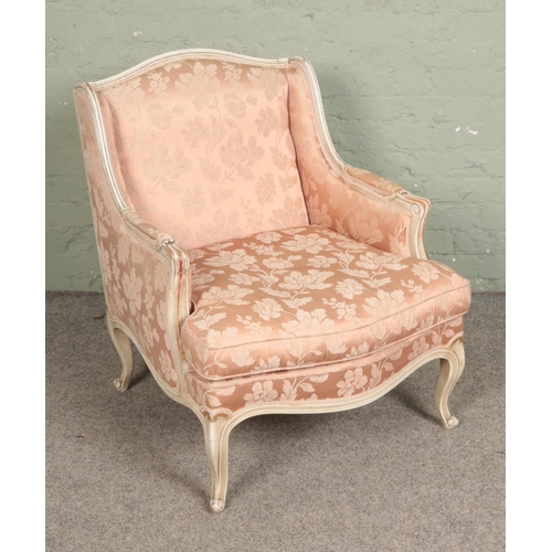 556 - A French painted bergere chair with floral upholstery.