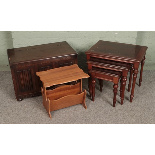 560 - A linen fold blanket box together with mahogany nest of tables and small magazine rack.