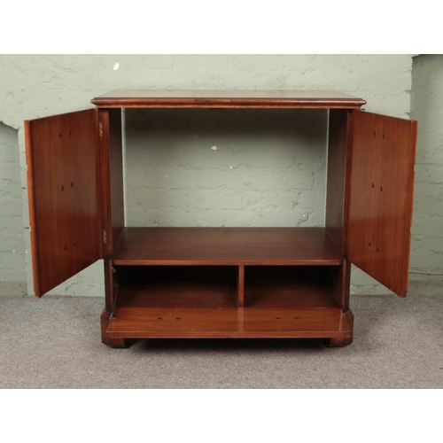 561 - A television cabinet in the form of a Georgian chest of drawers. With hinged double doors and pull d... 