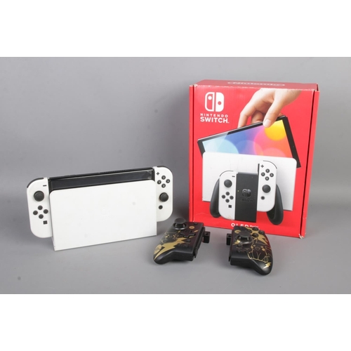 144 - A Nintendo Switch, OLED model with 64GB memory. With dock, charger, controllers and two additional H... 