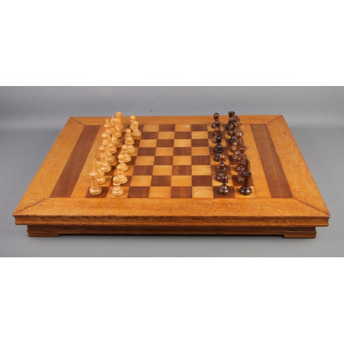 267 - A tabletop chess/checkers board along with a complete cased set of carved pieces.