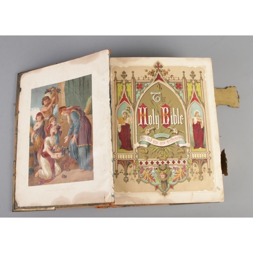 57 - An antique leather bound Holy Bible, with brass clasps and coloured plates. The Comprehensive Family... 