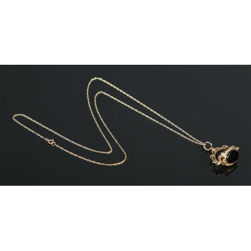 390 - A 9ct Gold three stone swivel fob, suspended on dainty 9ct Gold necklace chain. Total weight: 3.5g