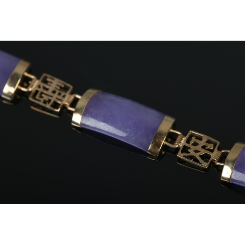 397 - A 9ct Gold and 'Lavender Jade' coloured bracelet, set with six pieces between pierced Oriental chara... 