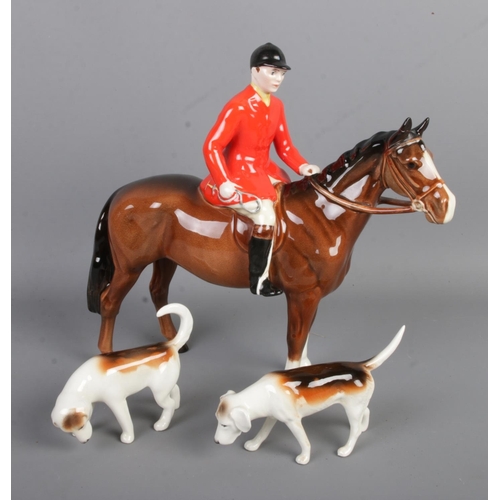 428 - A trio of Beswick ceramic hunting figures to include horse and rider along with two hunting dogs.