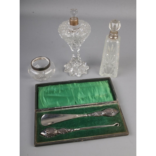 445 - A silver handles shoe horn and button hook in case with two silver mounted sent bottles