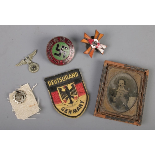 458 - A collection of German WW2 period badges and patches with a small ambrotype.