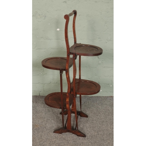 509 - An oak double folding cake stand featuring three tiers. Approx. height 88cm.