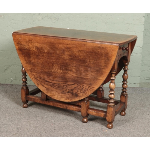 527 - An antique carved oak gateleg dining table, with bobbin turned supports and drawer to one side. Heig... 