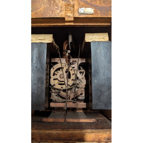 298 - A West German cuckoo clock in the Black Forest style, with carved detailing to the face and bird ped... 