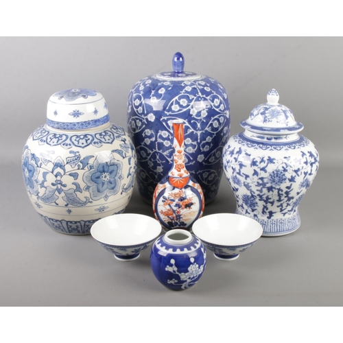 148 - A collection of oriental ceramics. Includes three large lidded blue and white jars, Imari bottle vas... 