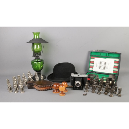 155 - An assortment of collectables, to include green glass oil lamp, 'The Baronet' bowler hat, backgammon... 