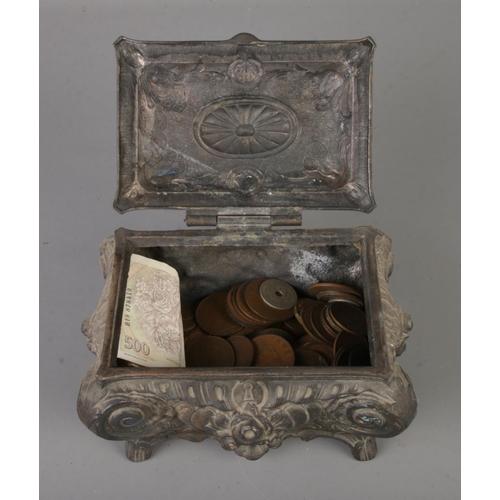 174 - An Art Nouveau pewter trinket box containing a small amount of mostly pre decimal and foreign coins.