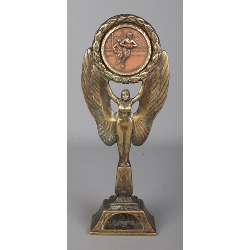 20 - A bronze rugby trophy formed as winged victory raising a copper plaque depicting two rugby players. ... 