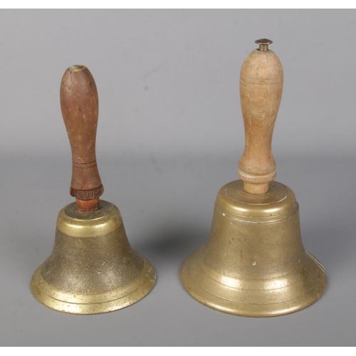 25 - Two vintage brass school bells with turned wooden handles.