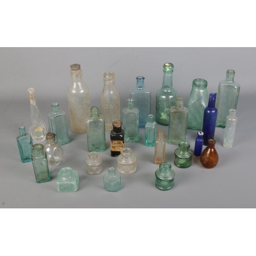 36 - A collection of assorted vintage glass bottles to include John Simms, Chemist, Lincoln and Bristol b... 