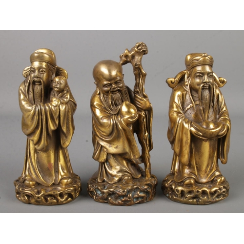 4 - Three Chinese bronze figures of sages, raised on stepped hardwood stand. Each figure bearing charact... 