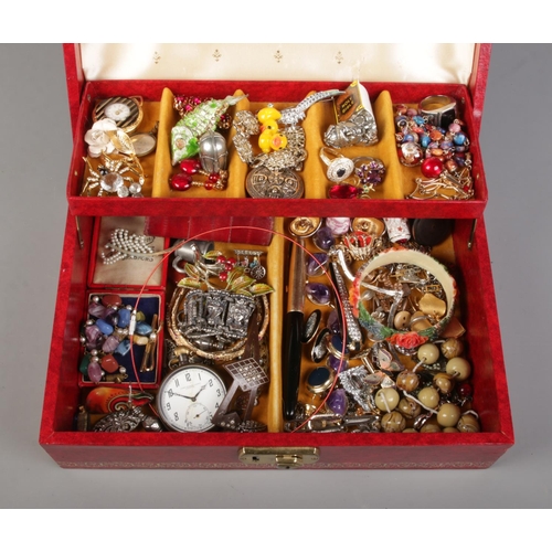 44 - A red cantilever jewellery box, containing a collection of costume jewellery. Includes articulated f... 