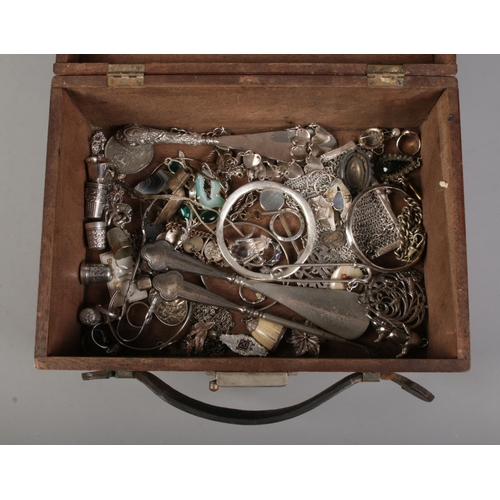 46 - A hinged mahogany case containing a collection of mainly white metal items. To include silver handle... 