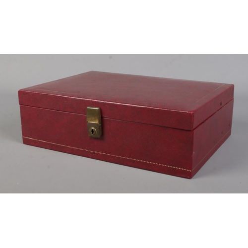 56 - A deep red cantilever jewellery box containing costume jewellery. Includes belt buckle, brooches, la... 