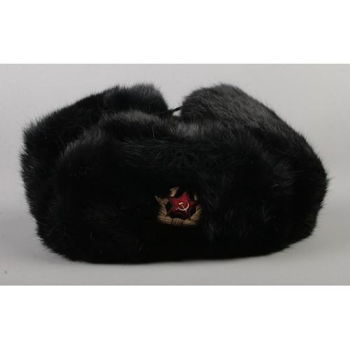 60 - A Russian Soviet Union black fur Ushanka hat bearing hammer and sickle crest to front.