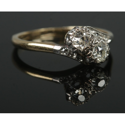 397 - An 18ct Gold two stone Diamond crossover ring, with small diamonds set into the shoulders. Size O½. ... 