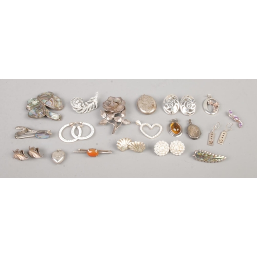 404 - A collection of vintage marked silver jewellery, to include earrings, large pendants, brooches and a... 